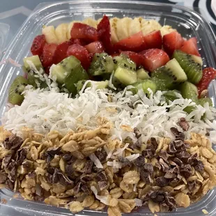 a bowl of cereal, strawberries, kiwi, and strawberries