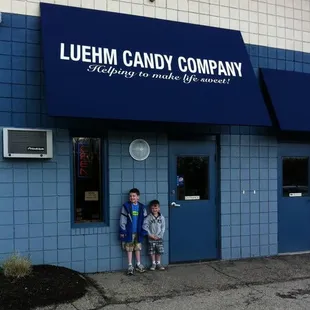 two children standing in front of a store