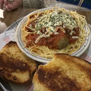 Spaghetti with meatballs comes with garlic bread.