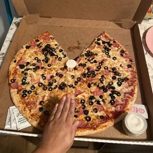 a hand grabbing a slice out of it