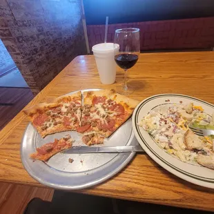 two plates of pizza and a glass of wine