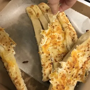 a hand grabbing a piece of bread