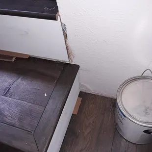 a bucket of paint next to a door