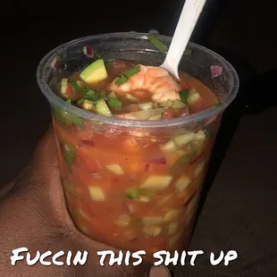 a hand holding a cup of soup