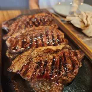 two steaks on a black plate