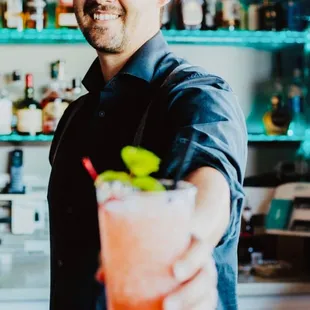 a bartender holding a cocktail