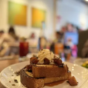 a plate of french toast with ice cream and syrup