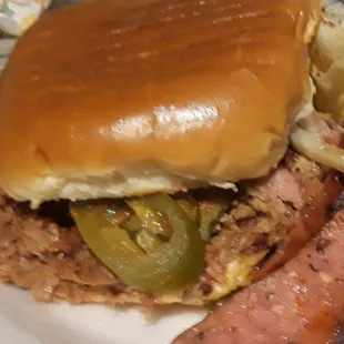 The Mae baby sandwich full of juicy beef, sausage, brisket, jalapenos, and onions.