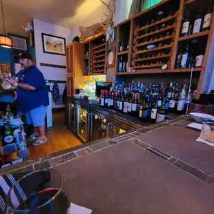 a man in a blue shirt standing at a bar