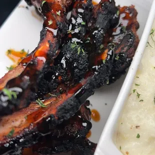 a plate of ribs and mashed potatoes