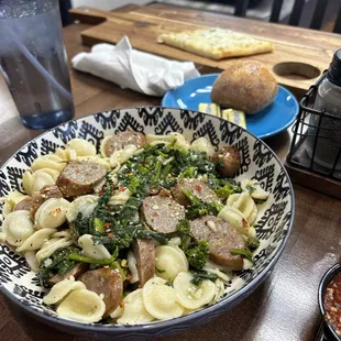 a bowl of pasta with sausage and broccoli