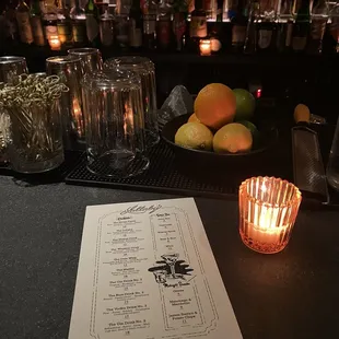 a menu and a lit candle at a bar
