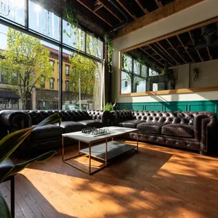 a living room with large windows and leather couches