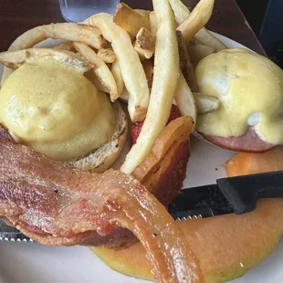Eggs Benedict, fries and side of bacon