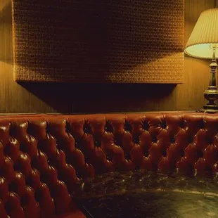 a corner booth with a table and two lamps