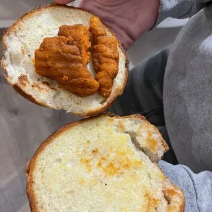 a hand holding a chicken sandwich