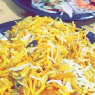 a plate of rice with carrots and onions