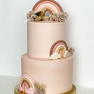 a three tiered cake with a rainbow on top