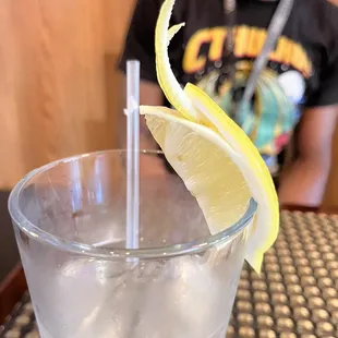 a glass of water with a lemon wedge