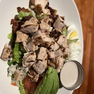 a white plate with a salad and dressing