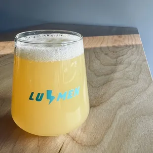 a glass of lumen beer on a wooden table