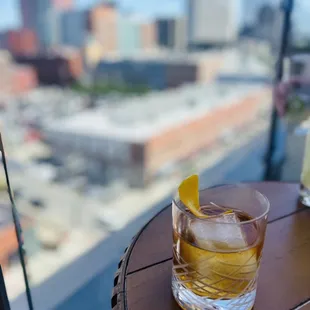 a drink on a table with a view of the city
