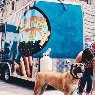 a woman and her dog in front of a food truck