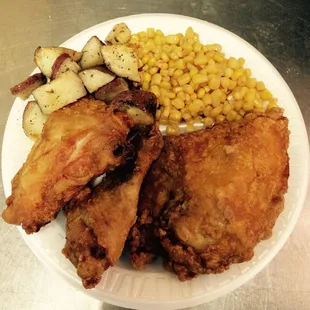a plate of fried chicken, potatoes, corn and potatoes