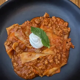 a plate of pasta with a dollop of sour cream