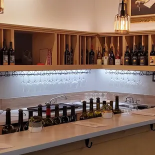 a bar with wine glasses and bottles