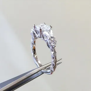 Custom Engagement ring with Princess cut center stone flanked by 4 marquis cut diamonds and 4 round diamonds.