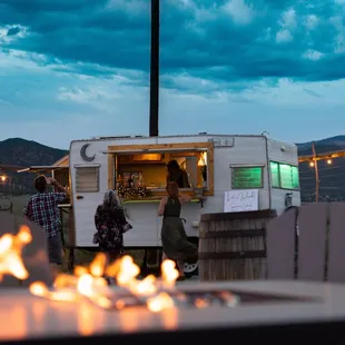 two people standing in front of a food truck