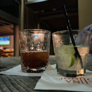 two glasses of drinks on a table