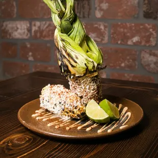 - Elote - grilled whole corn on the cob, cotija, ground chile, aioli, lime