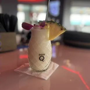 a drink with a pineapple garnish