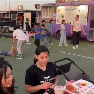 a group of people standing around a food truck