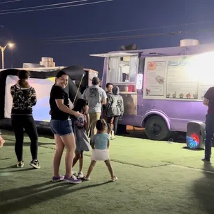 a group of people standing in front of a food truck