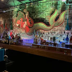 a brick wall with a mural of a mermaid on it