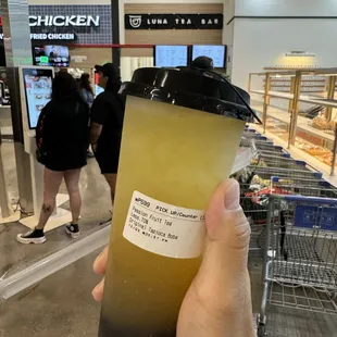 a person holding a drink in a store