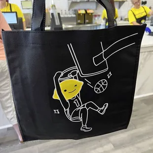 a woman holding a black bag with a cartoon character on it