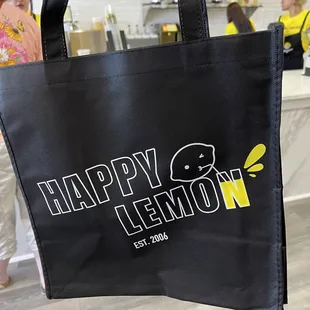 a black tote bag with a yellow bee on it