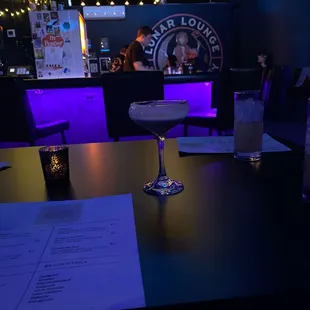 a table with a drink and menu