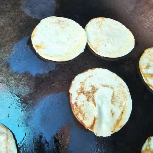 a pan of pancakes cooking on a grill