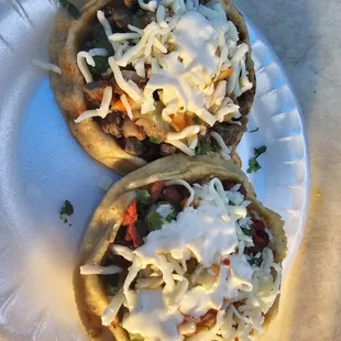 two tacos on a paper plate