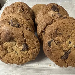 four chocolate chip cookies in a plastic container