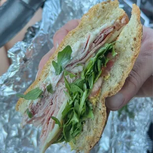 a person holding a sandwich