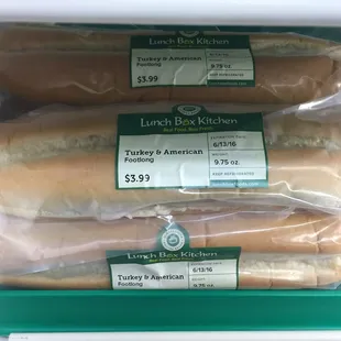 three sandwiches wrapped in plastic wrap