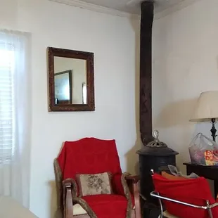 The wood heater in the corner next to the desk.