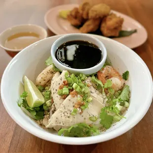 Kuy Teav Kohok Phnom Penk: Rice Noodles w/ shrimp, pork three ways, crispy garlic, cilantro, scallion, sweet soy, side broth | $21