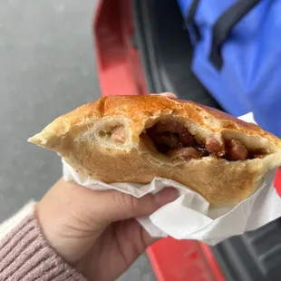 a hand holding a sandwich